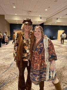 Two people pose in 1970s attire